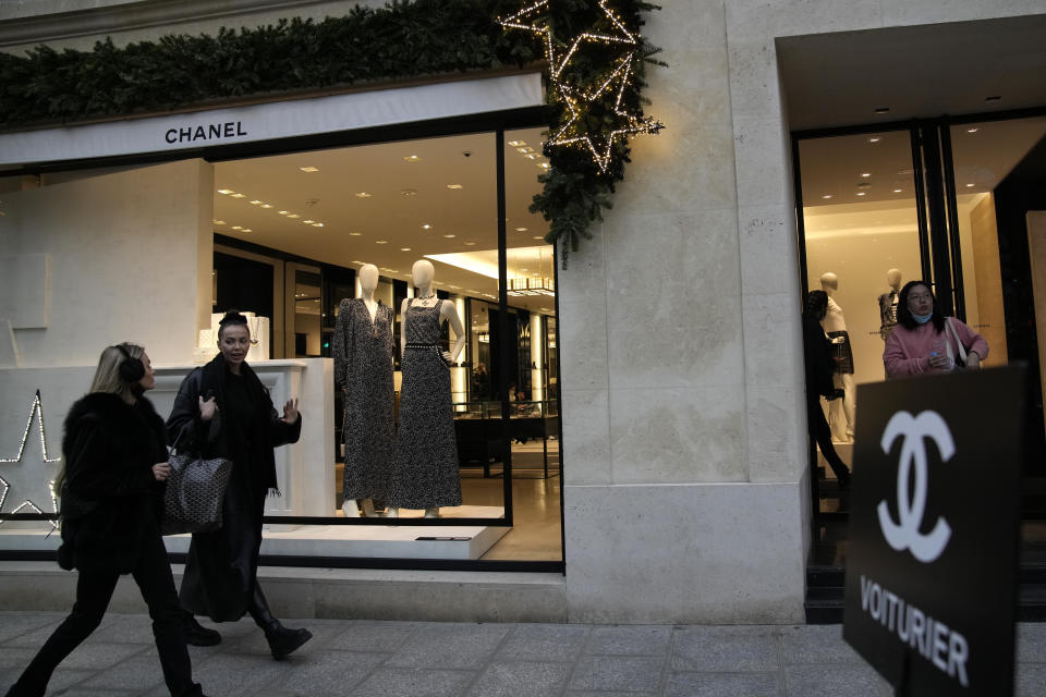 People walk past a Chanel boutique Wednesday, Dec. 15, 2021 in Paris. The French luxury fashion house Chanel has chosen Leena Nair, an industry outsider from India and longtime executive at Unilever, to be its new CEO. (AP Photo/Christophe Ena)