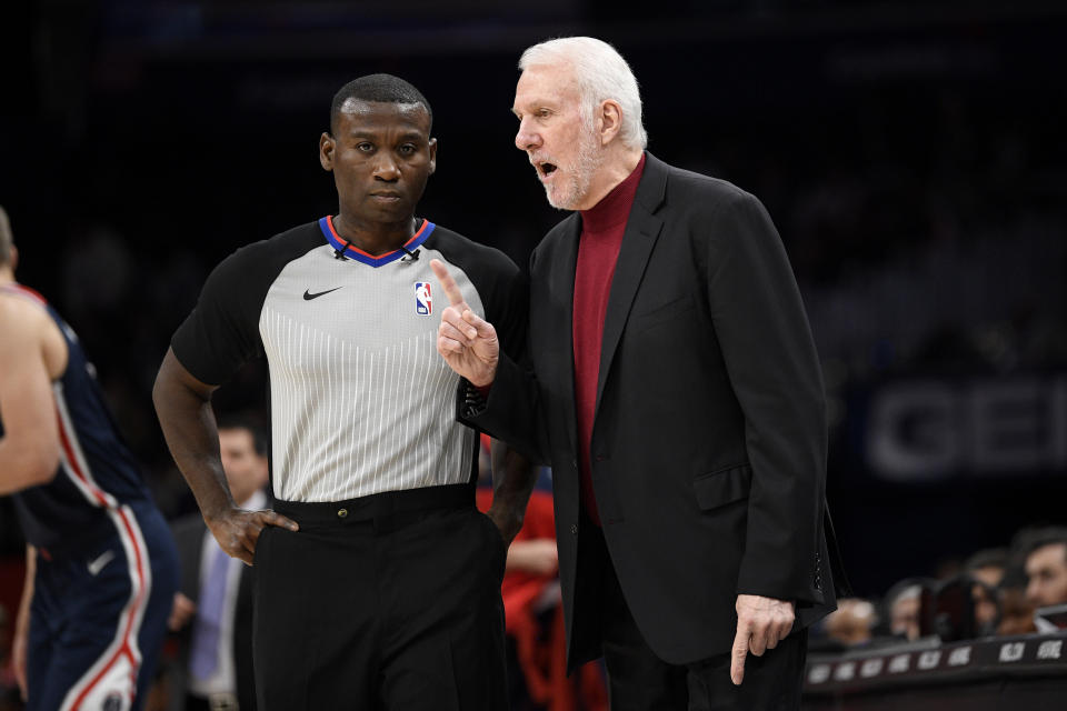 San Antonio Spurs coach Gregg Popovich, right, gestures next to an official during the second half of the team's NBA basketball game against the Washington Wizards on Wednesday, Nov. 20, 2019, in Washington. The Wizards won 138-132. (AP Photo/Nick Wass)