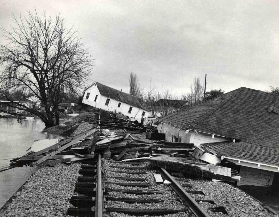 A house tilts at a crazy angle while another is buckled against a railroad embankment as flood waters recede in Yuba City on Dec. 25, 1955. The wreckage is indicative of the havoc left by the weekend inundation of a large section of Sutter County.