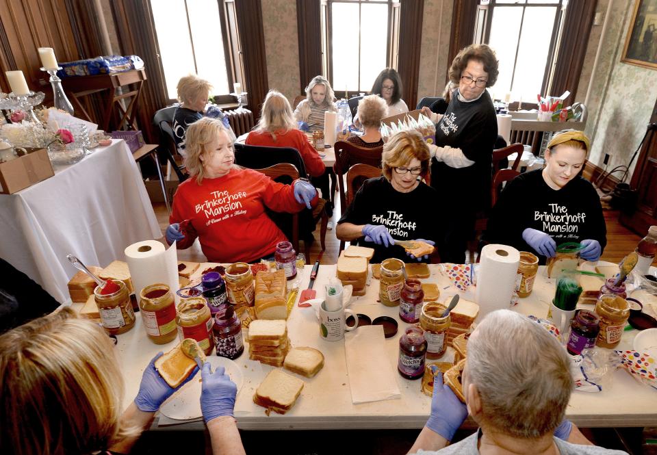 Volunteers make peanut butter and jelly sandwiches for the homeless at the Brinkerhoff Mansion on Tuesday, Feb. 27, 2024, in Springfield.