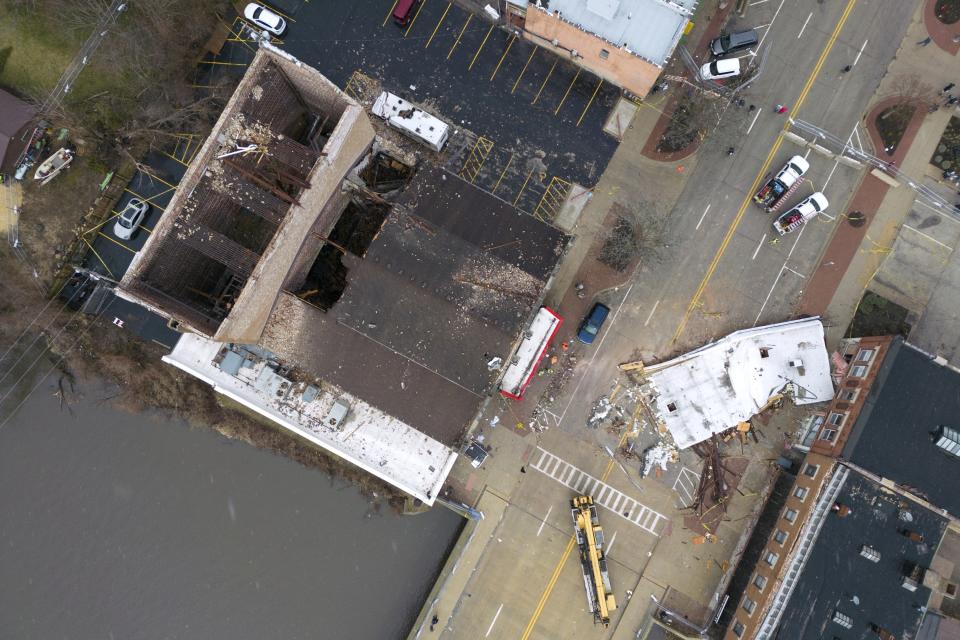 Crew members work to clean up debris at the scene where the roof of the Apollo Theatre collapsed during a tornado Saturday, April 1, 2023, in Belvidere, Ill. Belvidere Fire Chief Shawn Schadle said 260 people were in the venue. (AP Photo/Erin Hooley)