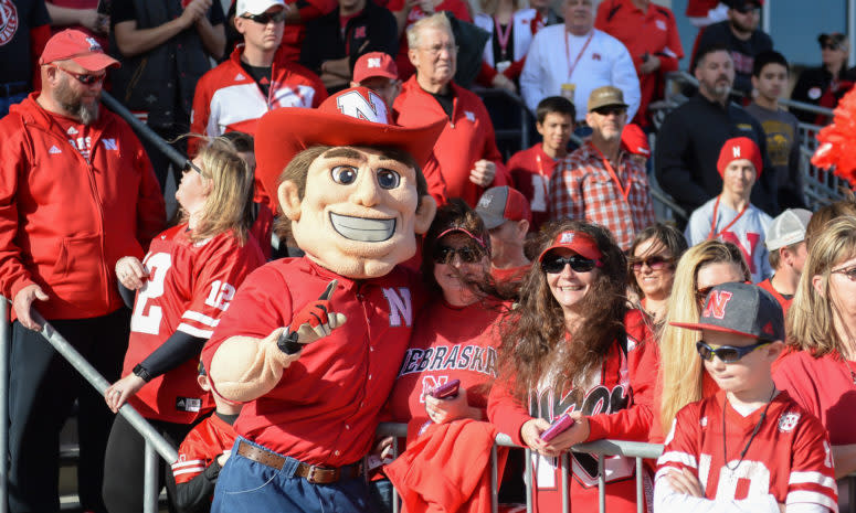 The Nebraska mascot celebrates with fans in the stands against Iowa.