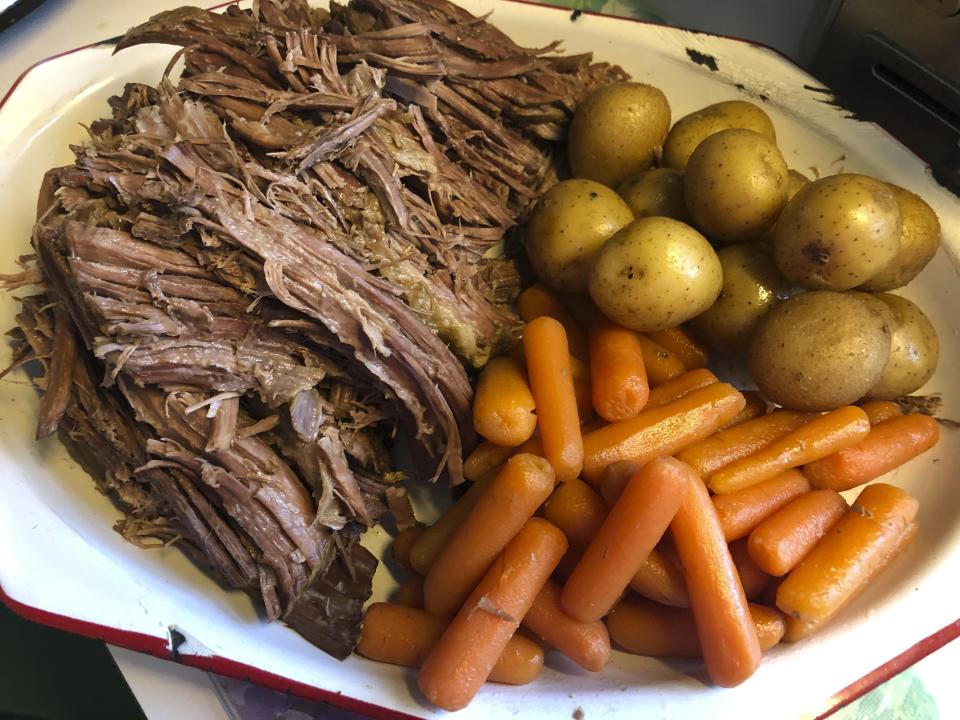 This image released by Kim Bierly shows a pot roast dinner with carrots and potatoes, made in a slow cooker. Before the coronavirus emerged, Bierly often worked late at her office and then met her husband for a quick dinner at one of the restaurants in their central Pennsylvania neighborhood. Now working from home, she's pulling out old recipes _ the kinds of things she remembers her mother making. (Kim Bierly via AP)
