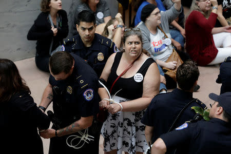 Protesters are arrested during a demonstration in opposition to U.S. President Donald Trump's Supreme Court nominee Brett Kavanaugh and in support for Dr. Christine Blasey Ford, the woman who has accused Kavanaugh of sexual assault, on Capitol Hill in Washington, U.S., September 20, 2018. REUTERS/Yuri Gripas