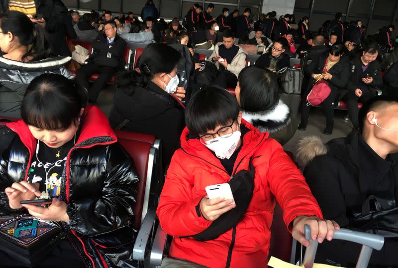 Passengers wearing masks are seen at the waiting area for a train to Wuhan at the Beijing West Railway Station, in Beijing