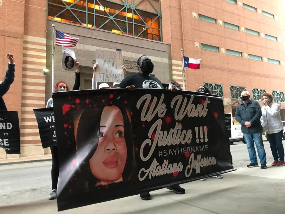 Kwame Osei (middle) holds up a banner for Atatiana Jefferson at a protest in March 2021 in downtown Fort Worth, TX demanding a trial date for the officer who shot and killed Jefferson in October 2019. Osei is a leader in Enough is Enough Fort Worth, the group that organized the event.