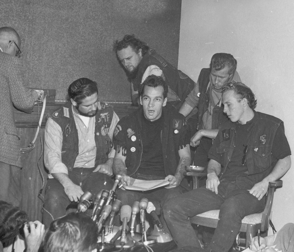 Ralph "Sonny" Barger, president of the Oakland chapter of the Hell's Angels, reads a statement during a news conference in Oakland, Ca., Nov. 19, 1965.  Barger announced they will not show up for the Vietnam Day Committee's march on the Oakland Army Terminal, Saturday.  The members of the Oakland Hell's Angels chapter from left are, Cliff Workman, treasurer; Barger; Tiny Walter, sergeant at arms; Ron Jacobson, secretary; and Tom Thomas, vice president, seated far right.