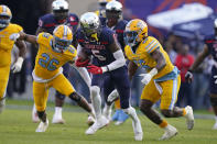 Jackson State wide receiver Shane Hooks (5) runs upfield after a pass reception between Southern University defensive back Rodney Johnson (26) and linebacker Jalan Campbell (56) during the first half of the Southwestern Athletic Conference championship NCAA college football game Saturday, Dec. 3, 2022, in Jackson, Miss. (AP Photo/Rogelio V. Solis)