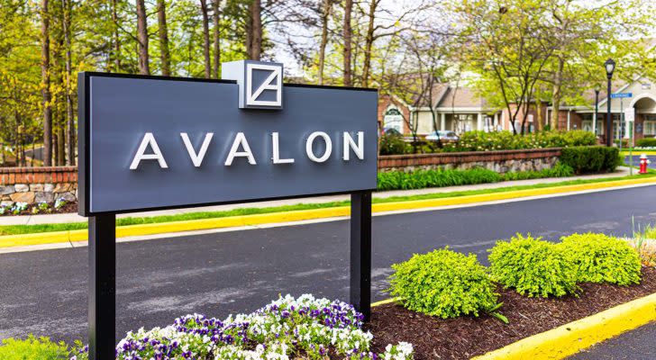 AVB stock: an Avalon sign in a garden next to a road