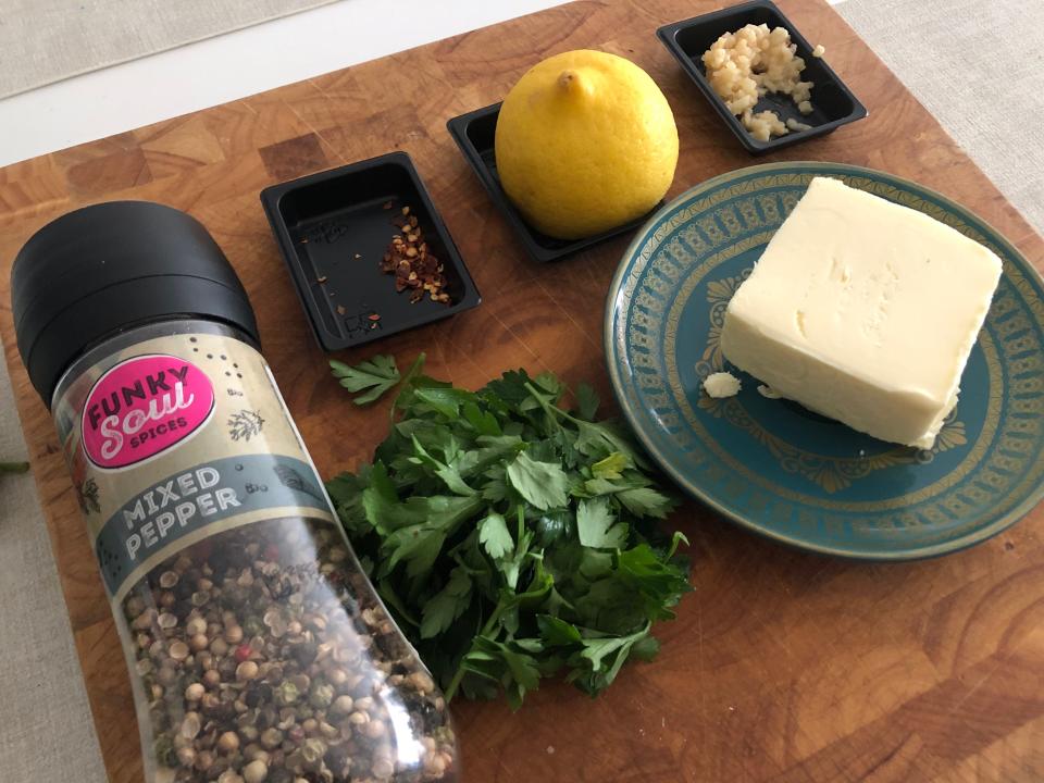 Ingredients for cowboy butter - black pepper, parsley, red-pepper flakes, lemon, garlic and butter