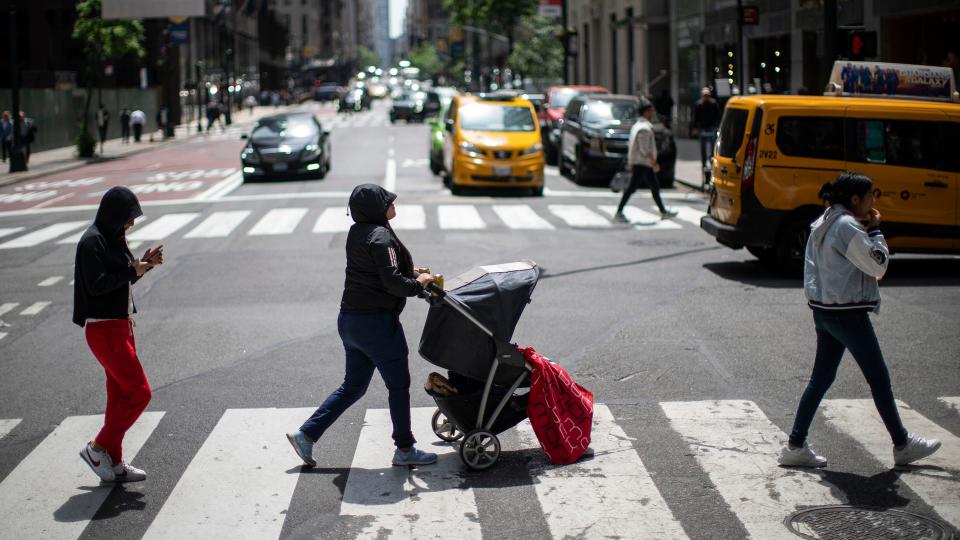 Asylum seekers walk around midtown Manhattan after being located in the Roosevelt hotel on Friday, May 19, 2023, in New York City.