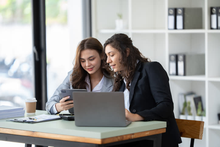 Two financial advisors reviewing their service model to create a personalized experience for clients.