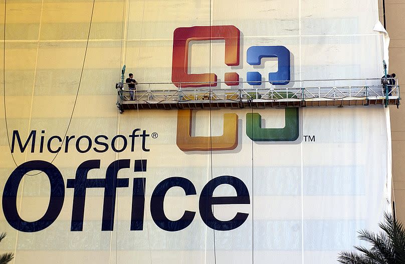 Workers place a giant Microsoft Office "wrap" on a hotel across from the Las Vegas Convention center, Friday, Nov. 14, 2003.