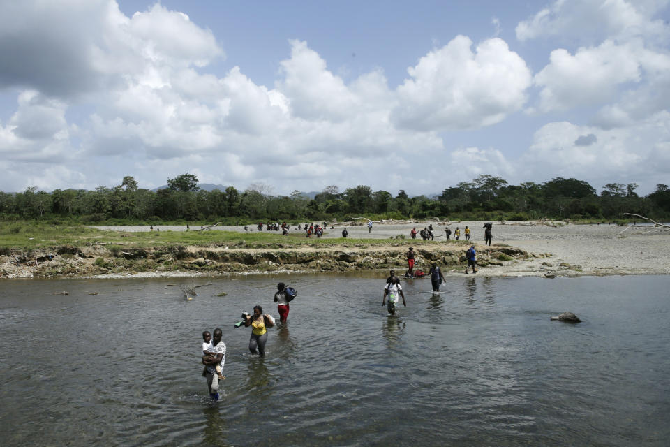 Haitian migrants cross the Tuquesa river after a trip on foot through the jungle to Bajo Chiquito, Darien province, Panama, Wednesday, Feb. 10, 2021. After nearly a year stalled in migrant camps at the edge of the jungle, hundreds of migrants have begun to move across Panama and into neighboring Costa Rica in recent weeks. (AP Photo/Arnulfo Franco)