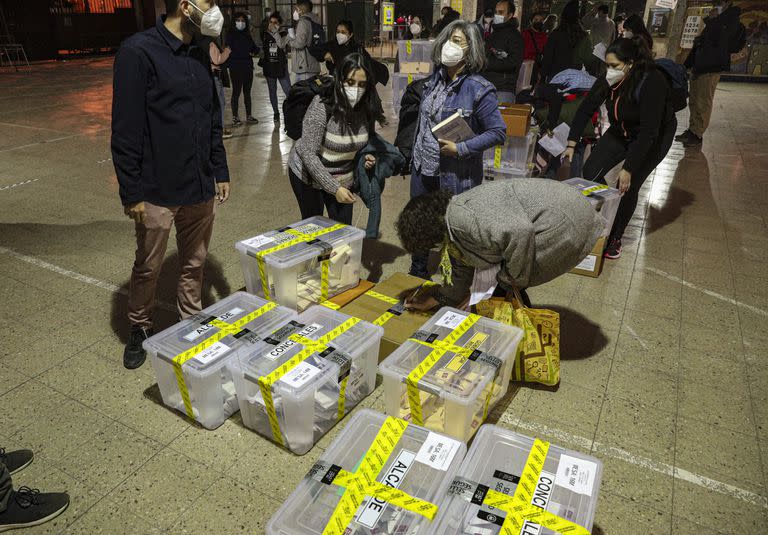 Trabajadores electorales custodian las urnas selladas al cabo de la jornada electoral