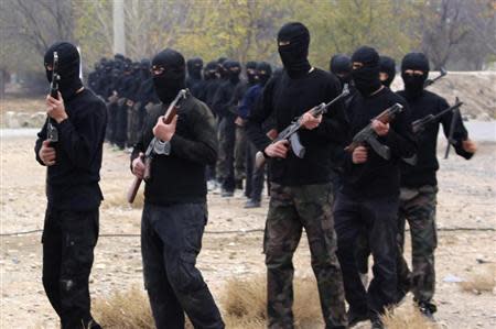 Islamist fighters walk with their weapons during their graduation ceremony at a camp in eastern al-Ghouta, near Damascus November 28, 2013. REUTERS/Diaa Al-Din