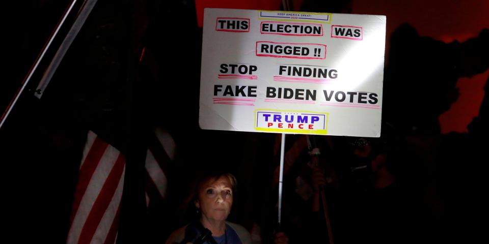 Donald Trump supporter Judy Goff illuminates her sign with a flashlight as she joins others in protesting the Nevada vote outside Clark County Election Department on November 5, 2020, in North Las Vegas. - President Donald Trump erupted on November 5 in a tirade of unsubstantiated claims that he has been cheated out of winning the US election as vote counting across battleground states showed Democrat Joe Biden steadily closing in on victory. (Photo by Ronda Churchill / AFP) (Photo by RONDA CHURCHILL/AFP via Getty Images)