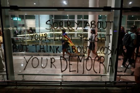 People walk past a graffiti at Barcelona's airport, after a verdict in a trial over a banned independence referendum
