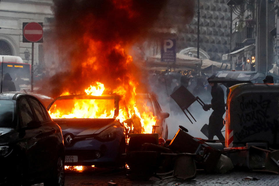 A police car is seen on fire during clashes between Eintracht Frankfurt fans and Italian police ahead of a UEFA Champions League soccer match between Napoli and Eintracht Frankfurt in Naples, Italy, on March 15, 2023.   