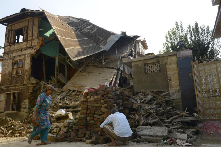 A Kashmiri man works at his flood-damaged house in Srinagar on October 3, 2014