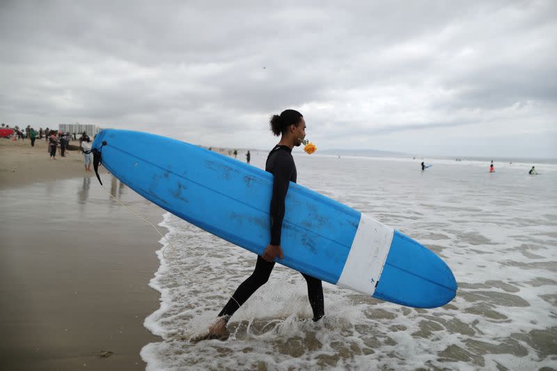 A man walks into the ocean at The Black Girls Surf paddle-out in memory of George Floyd, who died in Minneapolis police custody, in Santa Monica