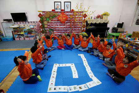 Vietnamese children play in front of images of late leaders North Korea's leader Kim Il and Vietnamese Ho Chi Minh at the Vietnam-North Korea Friendship kindergarten, founded by North Korean Government in Hanoi, Vietnam February 13, 2019. REUTERS/Kham