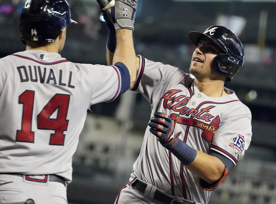 CORRECTS TO AUSTIN RILEY NOT FREDDIE FREEMAN - Atlanta Braves' Austin Riley, right, gets a high-five from Adam Duvall (14) after hitting a two-run home run against the Arizona Diamondbacks during the third inning of a baseball game Thursday, Sept 23, 2021, in Phoenix. (AP Photo/Darryl Webb)