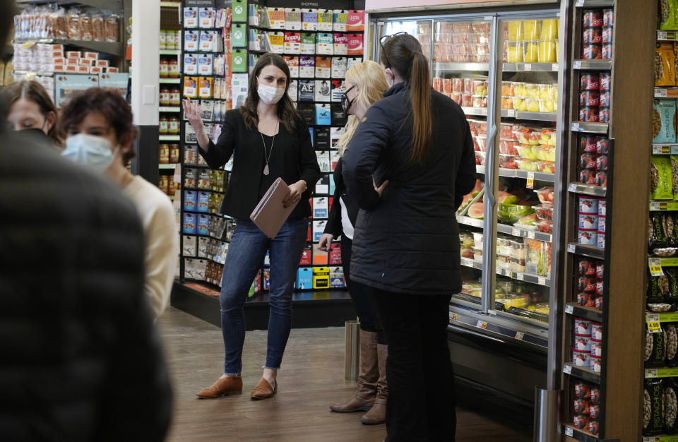 Jessica Trowbridge, center, spokesperson for the King Soopers grocery chain, speaks to media members about the Table Mesa King Soopers store during a media tour Tuesday, Feb. 8, 2022, in Boulder, Colo. Ten people were killed inside and outside the store when a gunman opened fire on shoppers in the store on March 22, 2021. The store reopens to the public Wednesday, Feb. 9. (AP Photo/David Zalubowski)