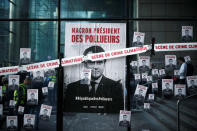 A poster and stickers with the slogan "Macron, President of polluters" are seen on the headquarters of French bank Societe Generale during a "civil disobedience action" by environmental activists to urge world leaders to act against climate change, in La Defense near Paris, France, April 19, 2019. REUTERS/Benoit Tessier