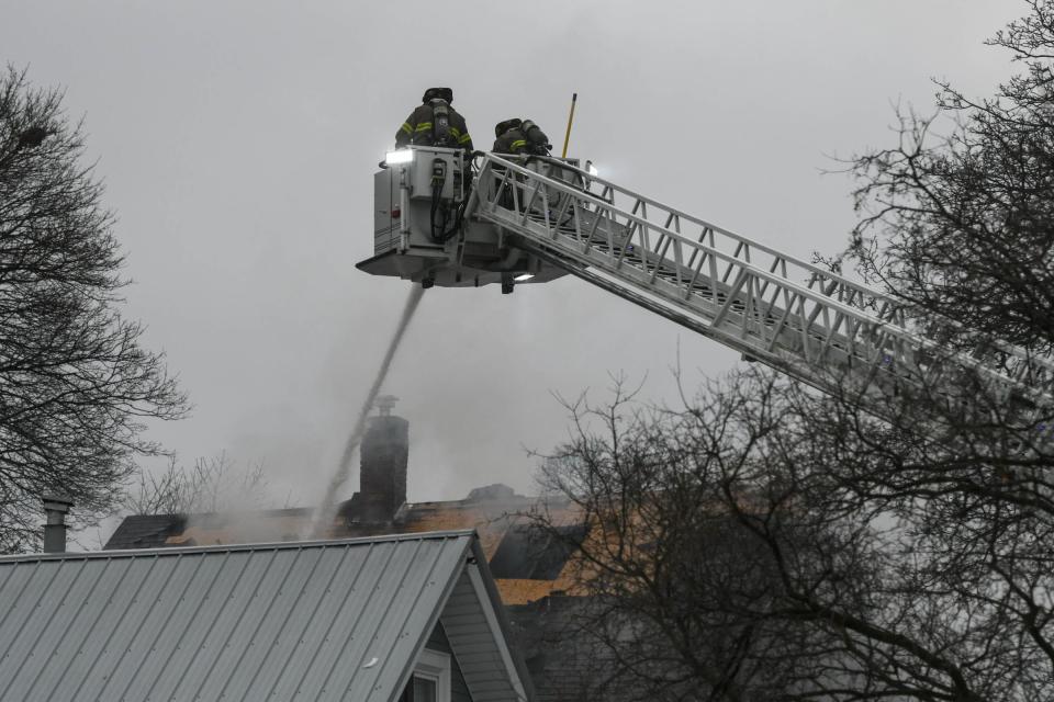 Firefighters with the Lansing Fire Department work at the scene at a fatal fire in the 500 block of Rulison in Lansing.