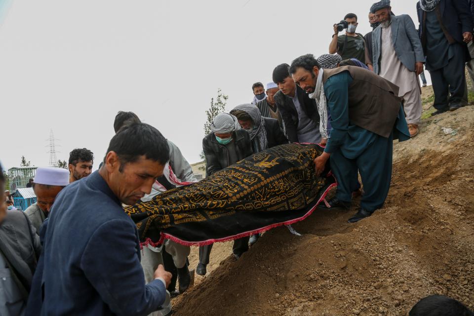 Mourners carry a covered dead body during a burial ceremony following a suicide attack in a maternity hospital, at a cemetery in Kabul on May 13, 2020. - The combined death toll from two attacks in Afghanistan, including one on a hospital in which infants and nurses were killed, has risen to 56, health officials said May 13. Three gunmen stormed a Kabul maternity hospital on May 12 as parents brought infants and children for appointments. (Photo by STR / AFP) (Photo by STR/AFP via Getty Images)