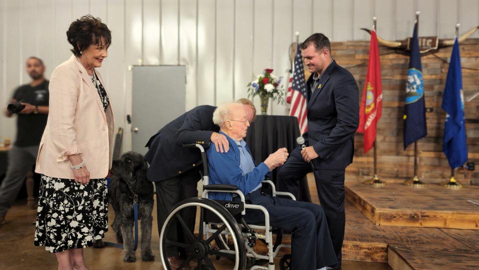 Melissa Kalka and , Lee Persefield  escort U.S.S. Indianapolis survivor  Cleatus Lebow to center stage by Blanke Siebrecht at the Armed Forces Day Banquet.