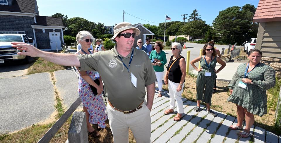 OneCape Summit participants join Greg Berman, Cape Cod Cooperative Extension and WHOI Sea Grant coastal processes specialist, and Heather McElroy (left) , Cape Cod Commission Natural Resources Manager, talk about erosion on Monomoy Wildlife Refuge Tuesday afternoon in Chatham.