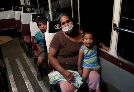 A woman and children are seen in a bus before evacuation in San Lorenzo Community an area where wildfires have destroyed hectares of forest, near Robore