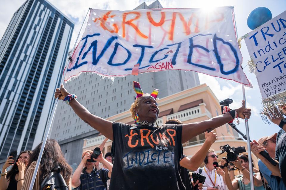 Nadine Seiler shouts and holds a sign reading "Trump Indicted" while standing outside the Wilkie D. Ferguson Jr. Courthouse on Tuesday, June 13, 2023, in Miami, Fla. Former President Donald Trump was scheduled to appear in federal court to be arraigned Tuesday afternoon, facing charges that he illegally retained national security documents after leaving office.