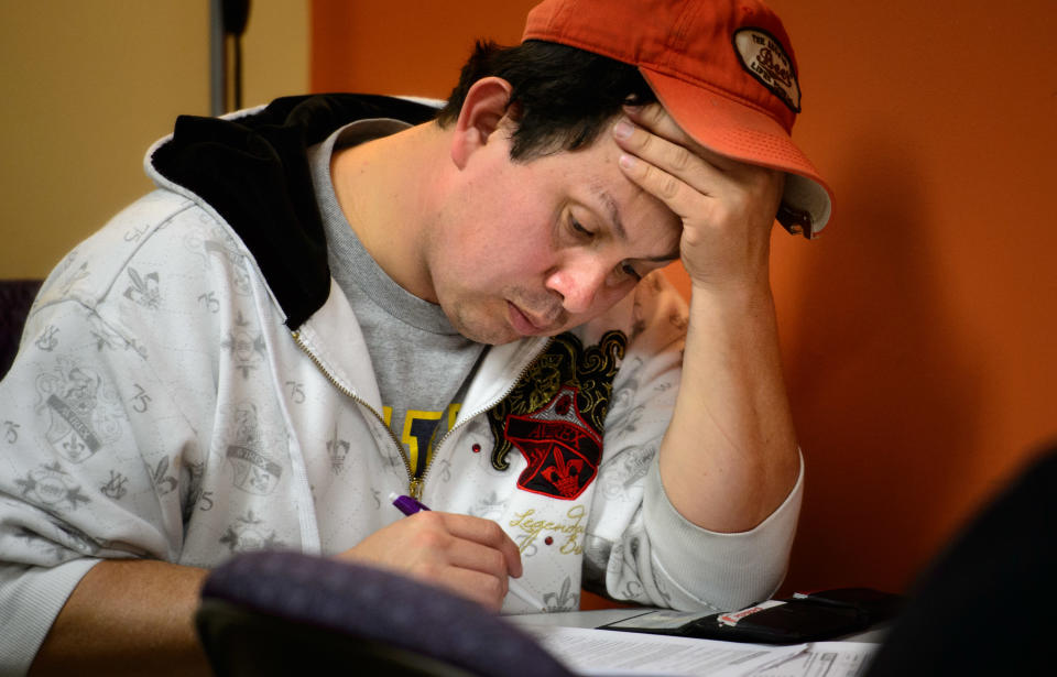 Raul Chavez of Shakopee holds his head as he starts on his MNsure application at Portico HealthNet, Monday, March 31, 2014, in St. Paul, Minn. The call center for Minnesota's online health insurance marketplace strained Monday under a crush of people trying to beat the midnight Monday deadline for open enrollment, while residents lined up to take advantage of locations offering in-person help. (AP Photo/Star Tribune, Glen Stubbe)