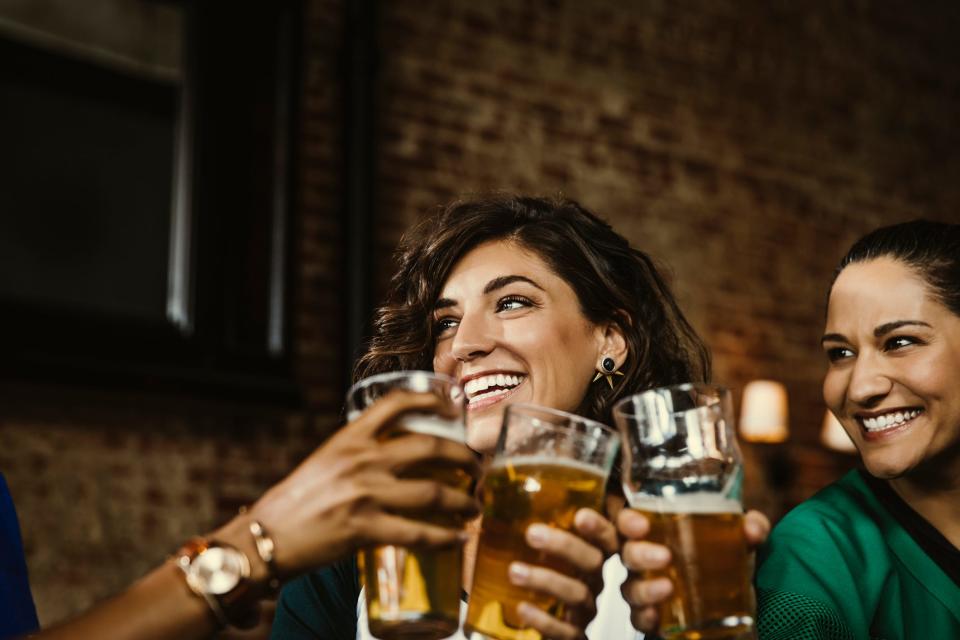 a group of friends celebrating happy hour with a round of beer