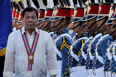 Philippine President Rodrigo Duterte walks past cadets to attend graduation ceremonies at the Philippine Military Academy in Baguio city, in northern Philippines March 12, 2017. REUTERS/Harley Palangchao