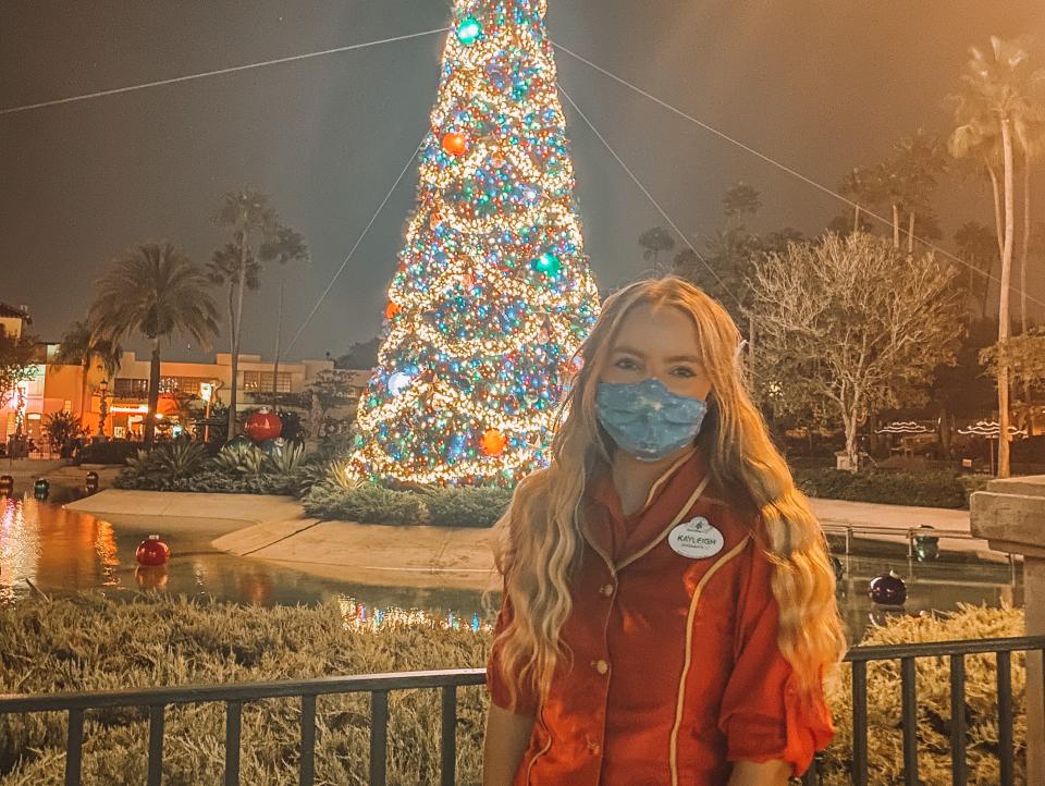 kayleigh standing in front of christmas tree at hollywood studios disney world