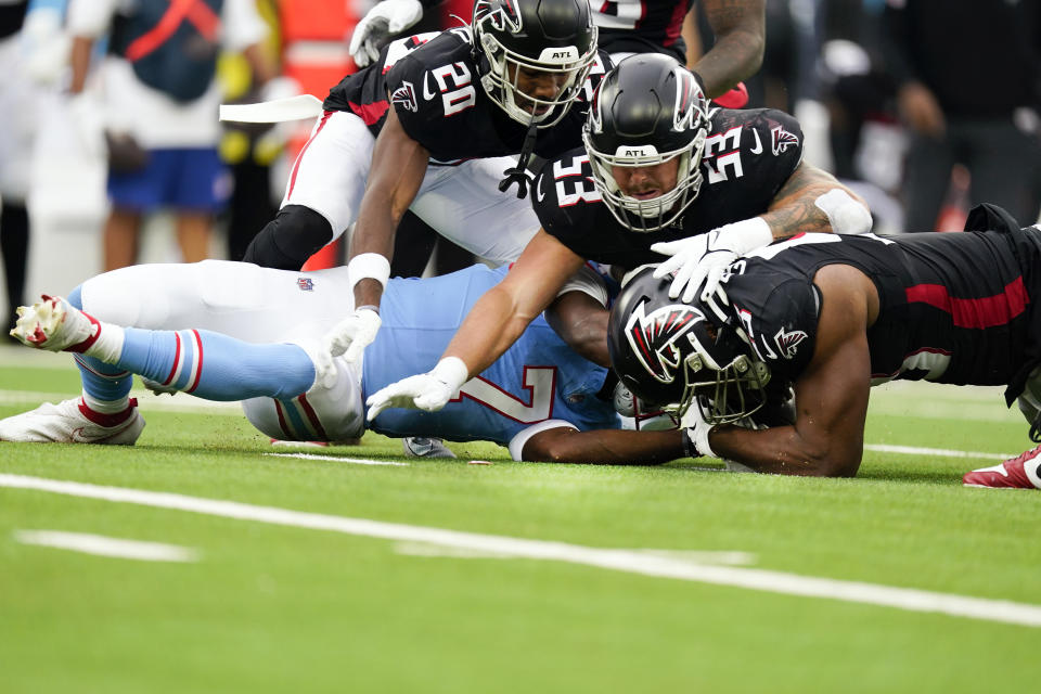 Tennessee Titans quarterback Malik Willis (7) battles Atlanta Falcons defenders Calais Campbell (93), Nate Landman (53) and Dee Alford (20) for the ball after fumbling the snap during the first half of an NFL football game, Sunday, Oct. 29, 2023, in Nashville, Tenn. (AP Photo/George Walker IV)