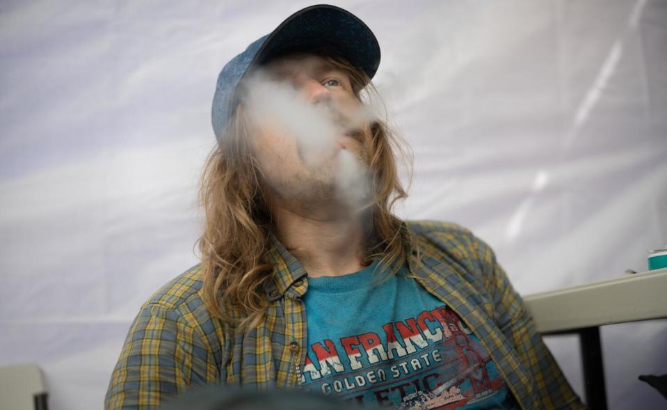 David Helgren smokes a drug at an illegal drug pop-up site on Willow and Polk streets in San Francisco.