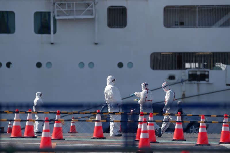 Workers in protective gear are seen near the cruise ship Diamond Princess at Daikoku Pier Cruise Terminal in Yokohama