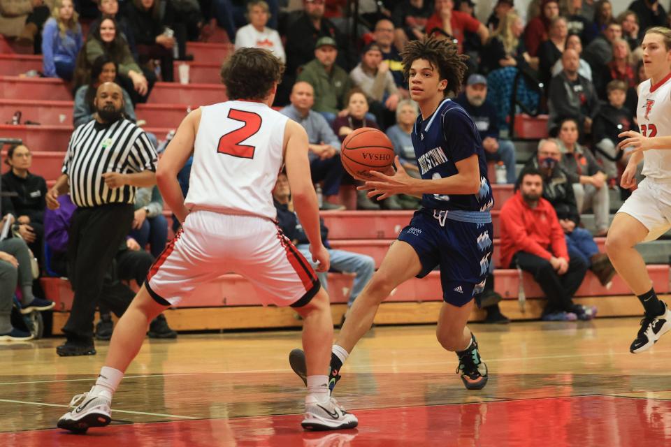 Rootstown senior Xavier Birkett attempts to drive past Field senior Jimmy Cultrona late in the second half of Tuesday night’s game at Field High School. Field defeated Rootstown 61-50.