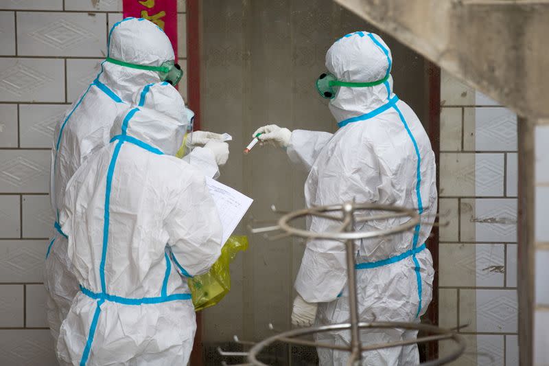 Workers collect environmental samples for COVID-19 testing at a village in Jinzhong