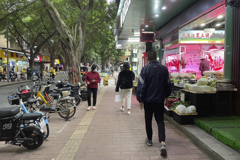 Residents walk past reopened stores in the district of Haizhu as pandemic restrictions are eased in southern China's Guangzhou province, Thursday, Dec. 1, 2022. More Chinese cities eased some anti-virus restrictions as police patrolled their streets to head off protests Thursday while the ruling Communist Party prepared for the high-profile funeral of late leader Jiang Zemin. (AP Photo)