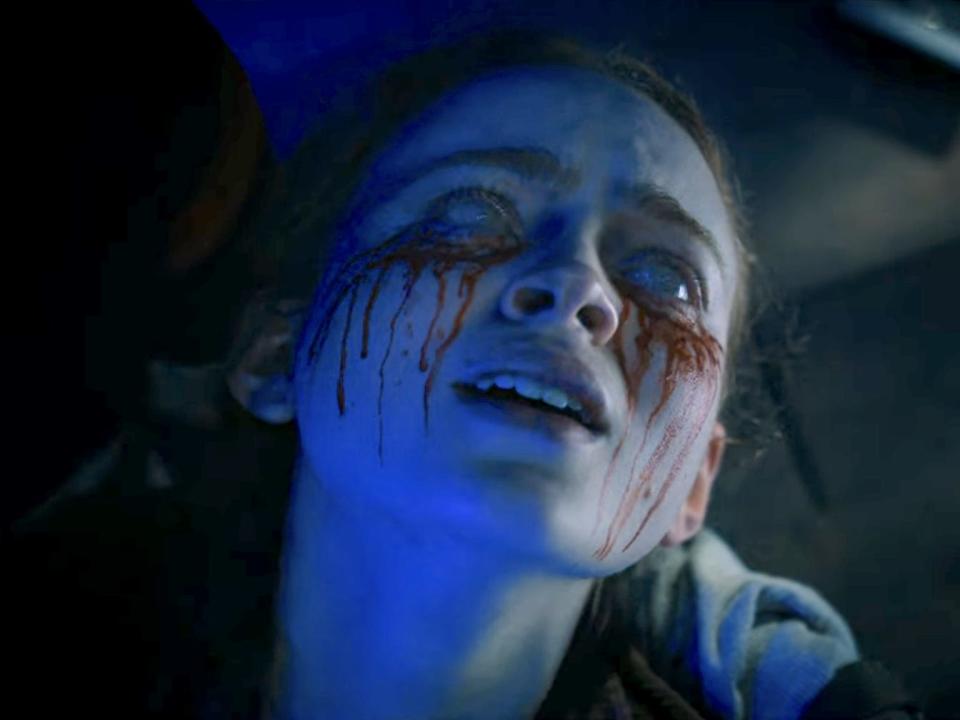 A scene from "Stranger Things" season four showing Max (a teenage girl played by Sadie Sink) with her eyes whited out and bleeding.