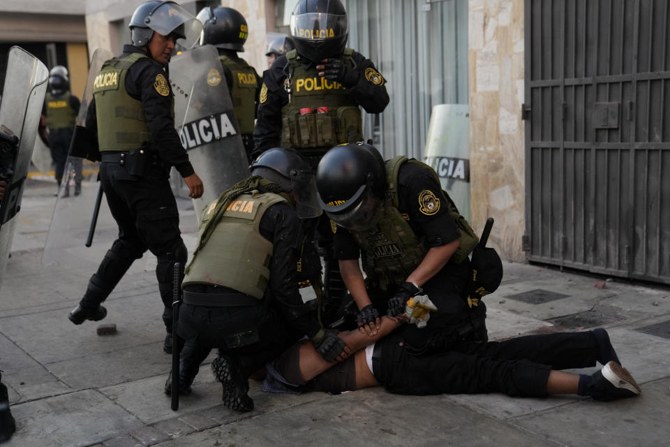 Police detain an anti-government protester in Lima, Peru, Tuesday, Jan. 24, 2023. Protesters are seeking the resignation of President Dina Boluarte, the release from prison of ousted President Pedro Castillo, immediate elections and justice for demonstrators killed in clashes with police. (AP Photo/Martin Mejia)