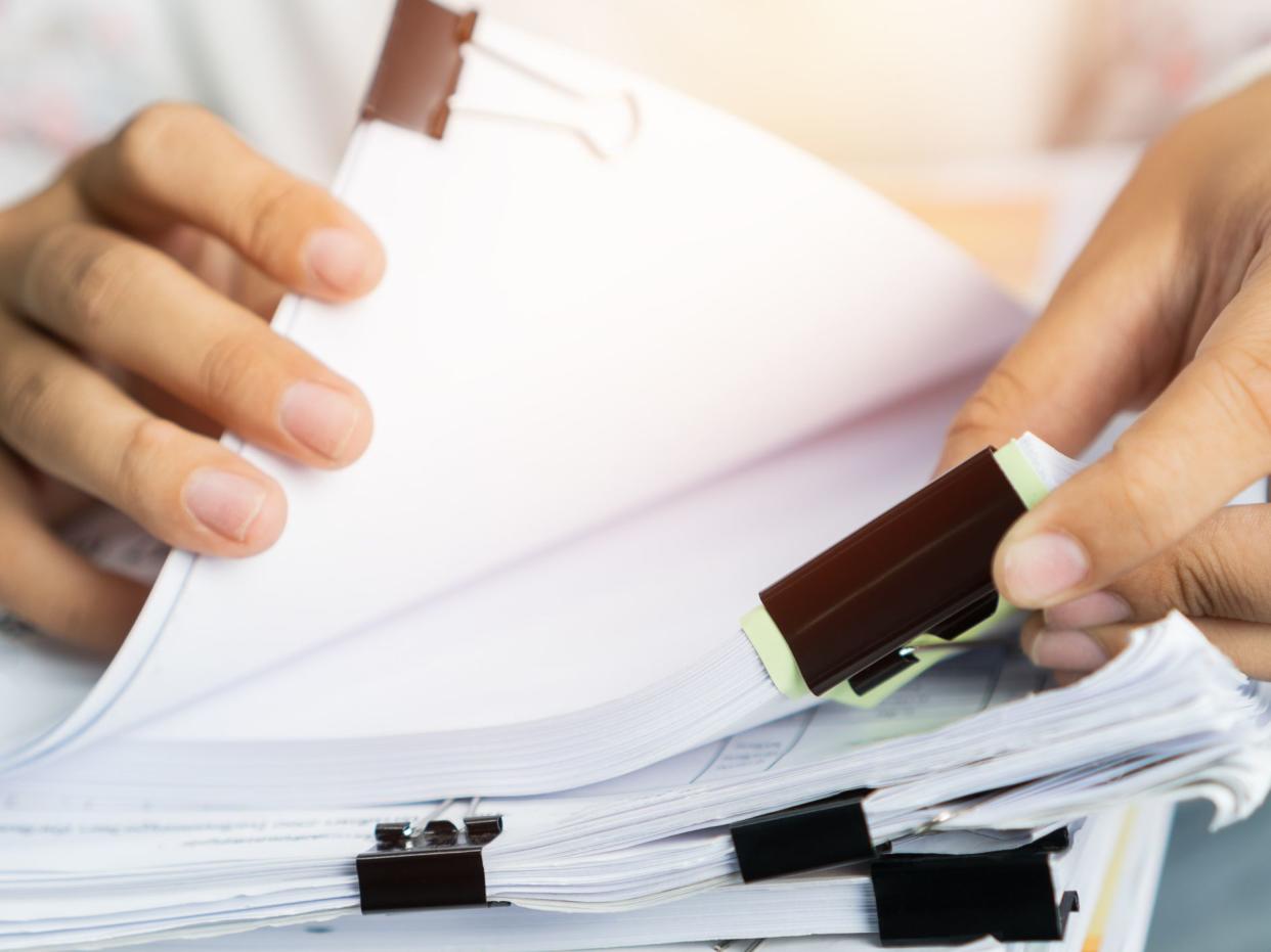 Businessman hands working in Stacks of paper files for searching information on work desk office, business report papers,piles of unfinished documents achieves with clips indoor,Business concept