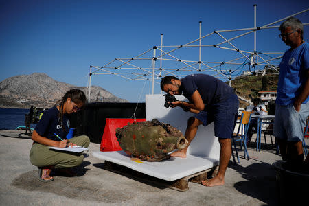 Student of the Department of Conservation of Antiquities and Works of Art Giorgos Agavanakis, 24, takes pictures as fellow student Eirini Mitsi, 23, takes notes on an amphora retrieved from a shipwreck site on the island of Fournoi, Greece, September 20, 2018. Picture taken September 20, 2018. REUTERS/Alkis Konstantinidis