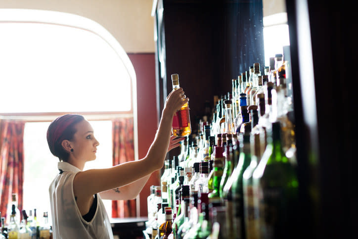 bartender grabbing a bottle